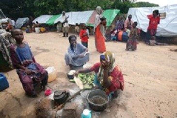 A group of Internally Displaced Somali women preparing food for their families at a makeshift camp.