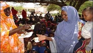 Displaced Somalia women helping each other and using trees for Shelter